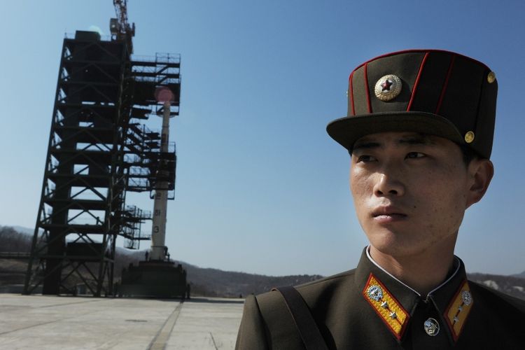 Tentara Korea Utara berjaga di dekat roket Unha-3 yang akan diluncurkan dari Stasiun Peluncuran Satelit Sohae di Tongchang-ri, April 2012.
