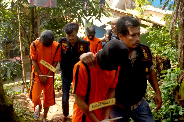 Tiga tersanga, DS, IM dan D digiring petugas kepolisan menuju tempat kejadian perkara di Desa Babakan, Kecamatan Cisaat, Sukabumi, Jawa Barat, Jumat (27/4/2018). 