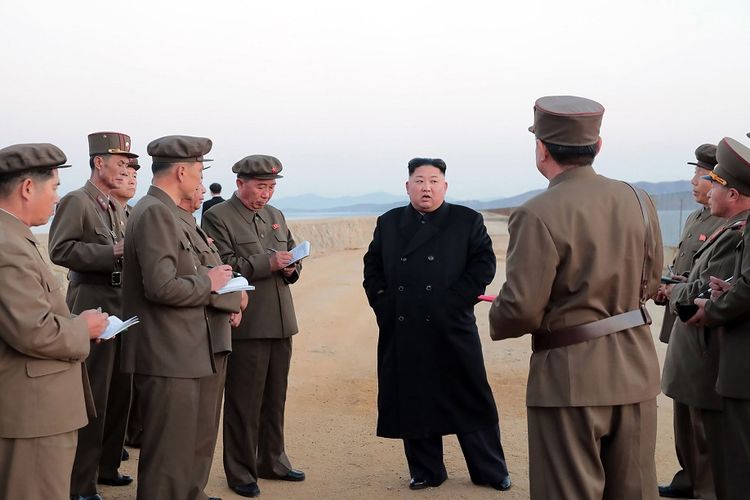 Pemimpin Korea Utara Kim Jong Un (bermantel hitam) memberi pengarahan kepada para pejabat militer setelah Korut mengklaim sukses mengujicoba senjata taktis berteknologi tinggi.
