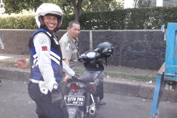Petugas Suku Dinas Perhubungan Jakarta Barat dan Satpol PP mengamankan sebuah sepeda motor di samping gedung CNI Puri Kembangan, Jakarta Barat pada Jumat (2/3/2018) karena memarkirkan kendaraan di badam jalan.