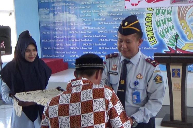 Kepala LPKA Kelas II Banda Aceh Ridha Ansari mnyerahkan remisi bebas kepada seorang anak didik di LPKA Banda Aceh dalam rangka peringatan Hari Anak Nasional 2019. sebanyak 18 anak mendapat remisi dan satu diantaranya bebas.