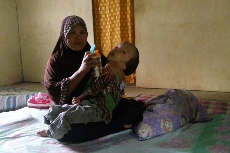 Aditiya Wahyu Indra digendong Ibunya Kaniyem di rumahnya di Padukuhan Bendo, Desa Krambilsawit, Kecamatan Saptosari, Gunungkidul, Yogyakarta.