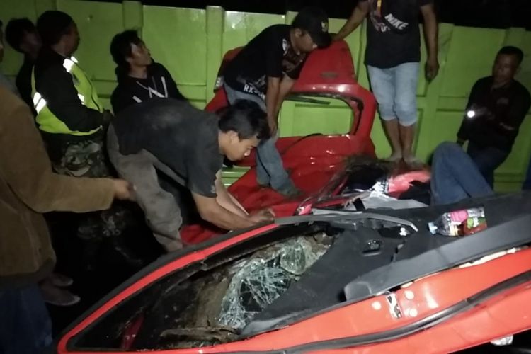 Petugas Kepolisian dan TNI dibantu warga sekitar sedang mengevakuasi satu keluarga tewas dalam mobil Agiya yang terjepit dalam kecelakaan maut di Tanjakan Gentong, Tasikmalaya, Sabtu (19/1/2019) dini hari tadi. 