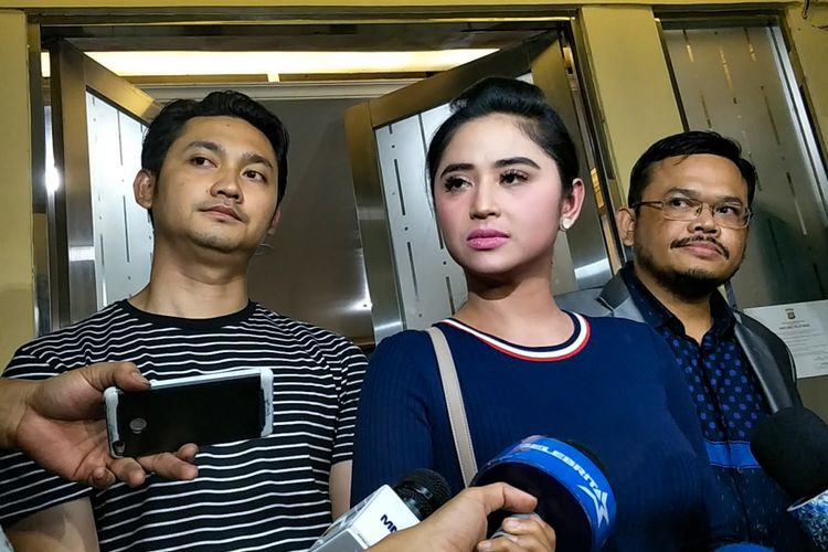 Penyanyi dangdut Dewi Perssik bersama sang suami, Angga Wijaya dan kuasa hukumnya, Maha Awan Buana usai dimintai keterangan oleh penyidik di Subdit Ranmor Polda Metro Jaya, Jakarta Selatan, Rabu (10/1/2018).