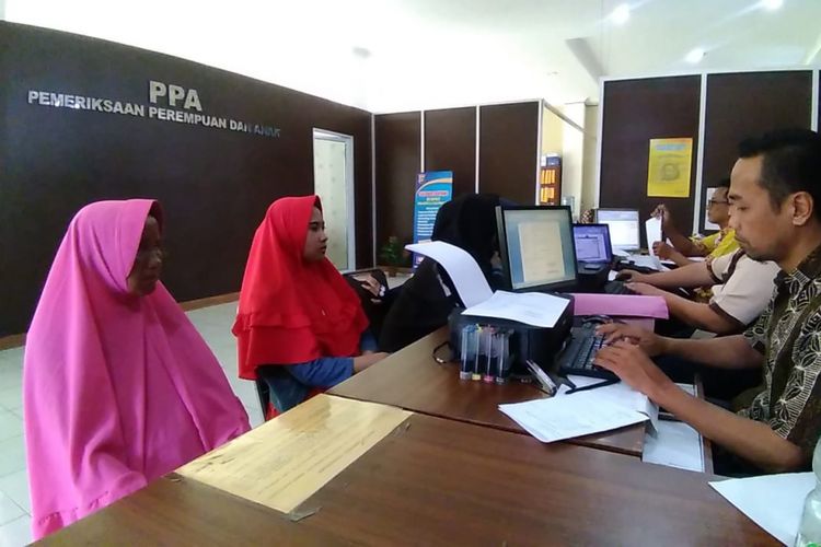 Sartika (25), bersama Ibunya Fatimah, ketika melaporkan salah satu akun Facebook di Polresta Palembang, Kamis (1/11/2018). Akun Facebook atas nama Heni Natalia sebelumnya menyebarkan foto Fatimah yang sedang berjualan buah dan dituduh sebagai pelaku penculikan anak yang sedang berkeliaran.