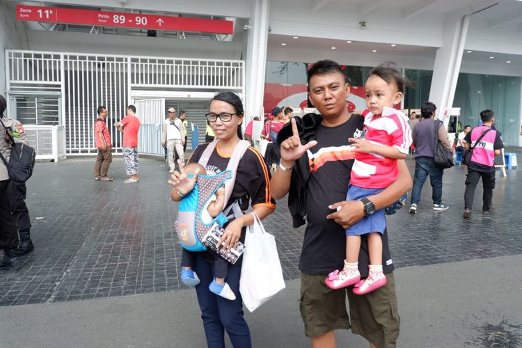 Pasangan suami-istri Jakmania membawa anak mereka yang masih balita ke pertandingan Persija vs Persib di SUGBK, Senayan, Jakarta.
