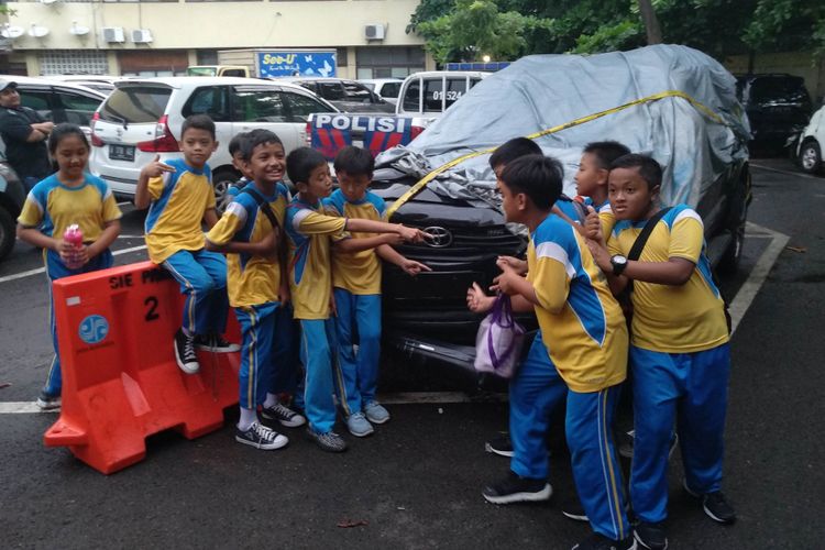 Anak-anak SD berfoto dengan Fortuner yang kecelakaan saat membawa Setya Novanto