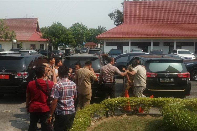 Dua orang mahasiswa yang melakukan protes pada rapat penanggulangan bencana karhutla di Gedung Daerah Riau diamankan petugas, Kamis (8/8/2019). Dok. Istimewa