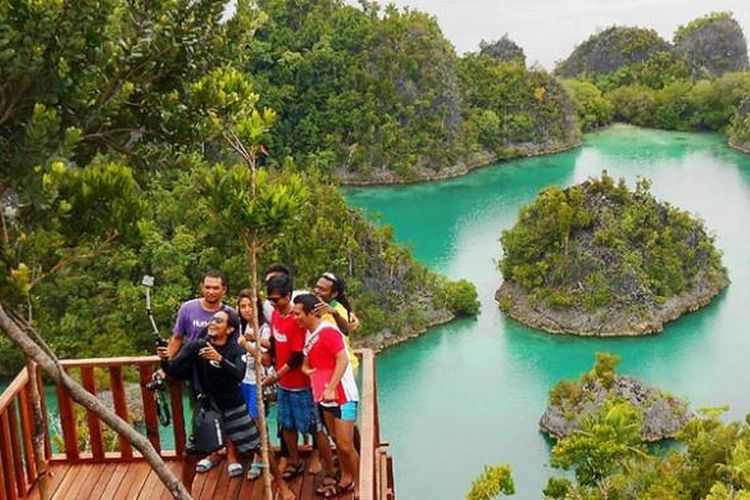 Pengunjung obyek wisata Telaga Bintang di Piaynemo, Kabupaten Raja Ampat, Papua Barat, memanfaatkan keindahan alam gugusan gunung-gunung karst dengan berfoto untuk promosi. Selain memiliki keindahan alam laut, kabupaten kepulauan ini juga memiliki pesona daratan yang belum banyak digarap. Potensi yang ditawarkan antara lain pengamatan burung cenderawasih, kakaktua, dan nuri serta trekking cagar alam.