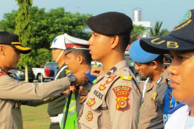 Kapolres Aceh Utara, AKBP Ian Rizkian memasang pita pada personel polisi tanda dimulainya operasi ketupat rencong pengamanan Idul Fitri di halaman Mapolres Aceh Utara, Aceh, Selasa (28/5/2019)