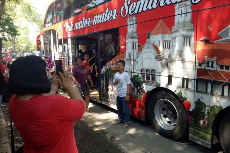 Wisatawan yang melihat bus tingkat wisata Semarang ini langsung berfoto di sisi bus gambar Kota Lama, Jumat (6/9/2017). Bus double decker ini, memang tak hanya menarik untuk dinaiki, tetapi banyak spot sefie di luar maupun di dalam mobil.