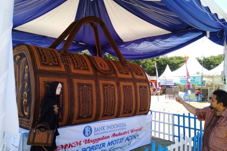 Staf Bank Indonesia, Deni Syahputra memperlihatkan tas raksasa di Gampong Expo, Lapangan Hiraq, Kota Lhokseumawe, Aceh, Jumat (25/8/2017)