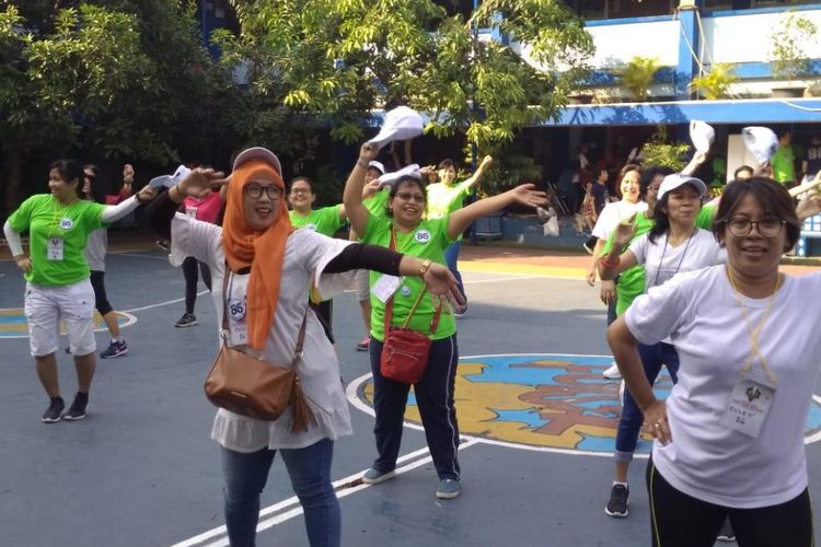 Peserta Fun Walk HUT ke-60 TK-SD Tarakanita 2 Jakarta melakukan pemanasan senam Go Green di halaman sekolah pada Minggu (29/7/2018). 