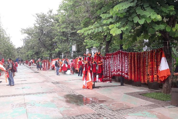 Sejumlah pedagang kaki lima (PKL) memanfaatkan keramaian perayaan kemenangan Persija di trotoar Jalan Medan Merdeka Selatan, Jakarta Pusat pada Sabtu (15/12/2018) untuk berdagang. 