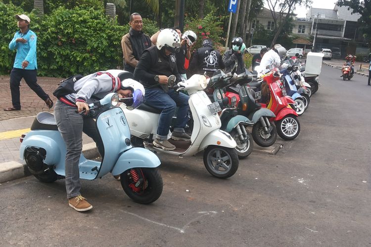 Para anggota komunitas vespa Kutu Community berkumpul di Taman Ayodya, Jakarta Selatan sebelum memulai kegiatan turing santai berkeliling Jakarta pada Senin (1/1/2018).