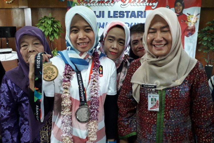 Atlet panjat tebing Puji Lestari memamerkan dua medali Asian Games 2018 yang diraihnya bersama Lurah Marunda Hilda Damayanti, Kamis (30/8/2018).