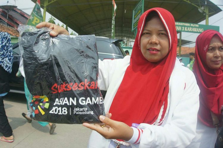 Presiden Jokowi membagikan kaos bertuliskan Sukseskan Asian Games 2018 kepada warga di Desa Sukatani, Kecamatan Cilamaya Wetan, Kabupaten Karawang, Rabu (6/6/2018).