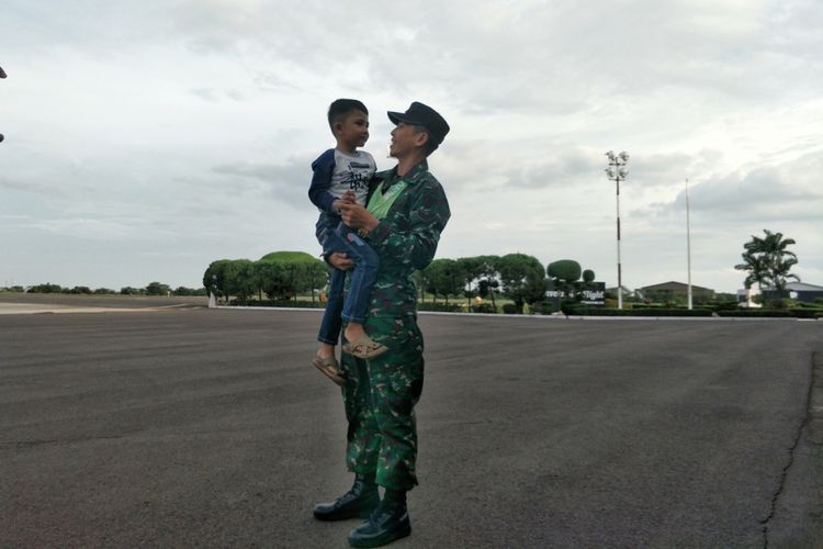 Sersan Satu (Sertu) Woli Hamsan menggendong anaknya, Rizki (5) di Base Ops, Halim Perdana Kusuma, Jakarta Timur, Jumat (24/11/2017) sore. Sertu Woli Hamsan merupakan salah satu dari 62 personel kontingen Lomba Tembak antar Angkatan Darat Negara-negara ASEAN atau The ASEAN Armies Rifle Meet (AARM) 2017 di Singapura pada 14 November hingga 23 November 2017 lalu.