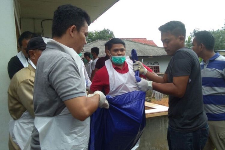 Anggota Polsek Bintan Timur saat mengevakuasi jenazah Abun yang tewas saat akan mendapatkan perawatan di rumah sakit. Abun tewas setelah dianiaya anaknya sendiri, Akun, yang diduga mengalami gangguan kejiwaan.