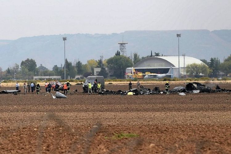 Petugas dari badan penyelamat Spanyol berjalan di tengah serpihan pesawat F-18 Hornet yang jatuh di dekat Pangkalan Torrejon de Ardoz (17/10/2017)