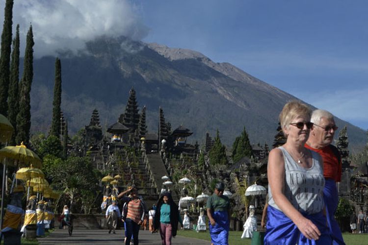 Sejumlah wisatawan mengunjungi kawasan Pura Besakih di Karangasem, Bali, Senin (2/7/2018). Kunjungan wisatawan ke kawasan Pura Besakih menurun 50 persen menjadi sekitar 400 pengunjung per hari pasca peningkatan aktivitas vulkanik Gunung Agung beberapa hari terakhir.