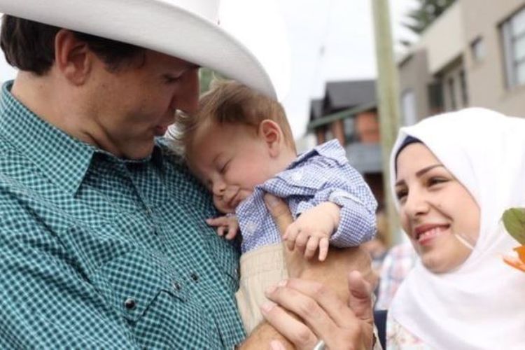 PM Kanada Justin Trudeau tengah menggendong seorang bayi anak pengungsi Suriah yang diberi nama Justin Trudeau.