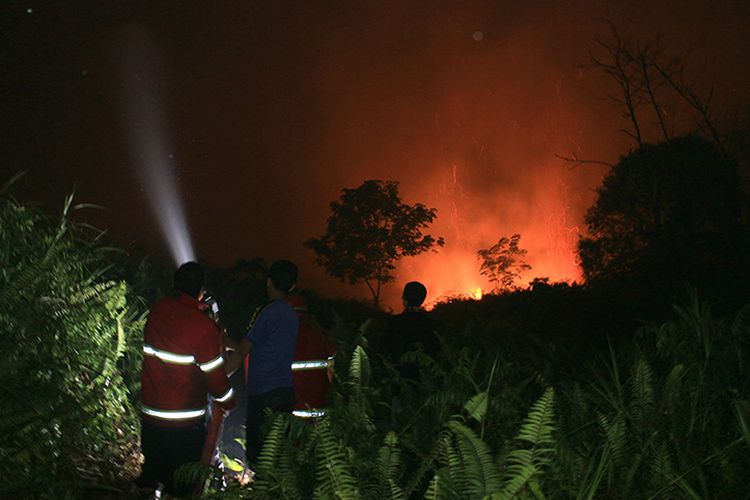 Petugas gabungan pemadaman api dari BPBD, polisi dan TNI melakukan pemadaman kobaran api yang berada sekitar 100 meter dari rumah warga Desa Suak Raya, Kecamatn Johan Pahlawan, Kabupaten Aceh Barat, Selasa (25/7/17).