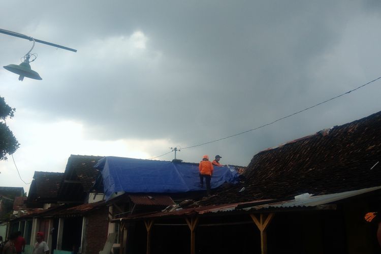 Warga dan relawan memasang terpal di atap rumah di RT 3 RW 8, Sorowajan, Banguntapan, Bantul.