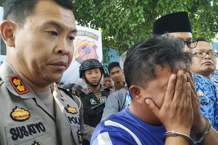 Tersangka ER menutup muka dengan tangan saat konferensi pers di halaman Gedung Juang 45 Sukabumi, Jawa Barat, Rabu (17/7/2019).