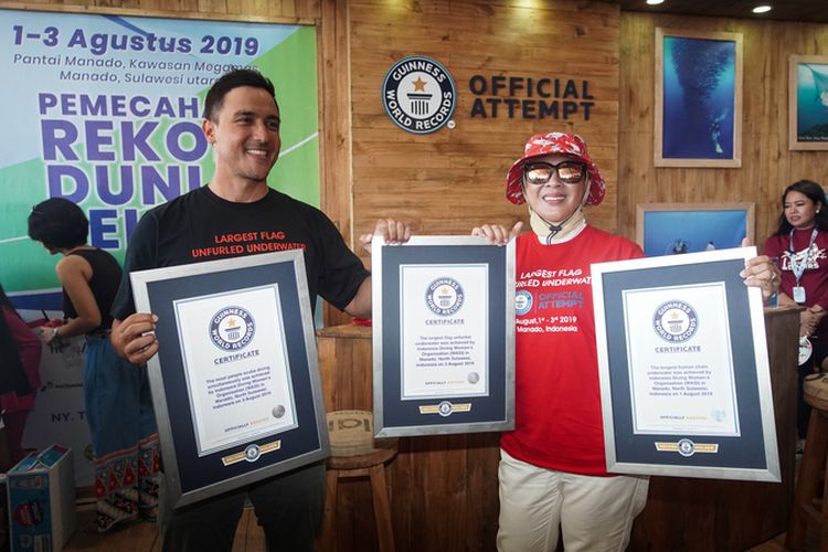 Aktor dan presenter Hamish Daud dan Ketua Wanita Selam Indonesia (Wasi) Tri Tito Karnavian memegang tiga sertifikat Guinness World Records untuk rekor dunia selam yang baru saja dipecahkan oleh Indonesia di Pantai Manado, Kawasan Megamas, Manado, Sulawesi Utara, Sabtu (3/8/2019).