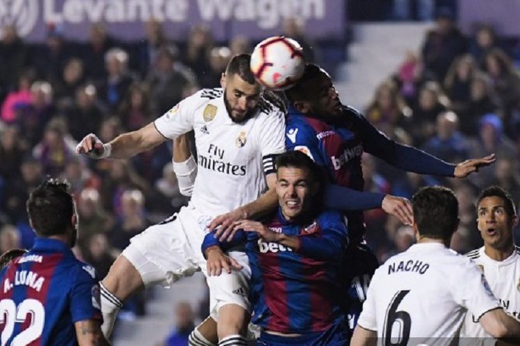 Striker Real Madrid Karim Benzema menyundul bola melawan penyerang Levante, Moses Simon, pada laga pekan ke-25 La Liga Spanyol, 24 Februari 2019.