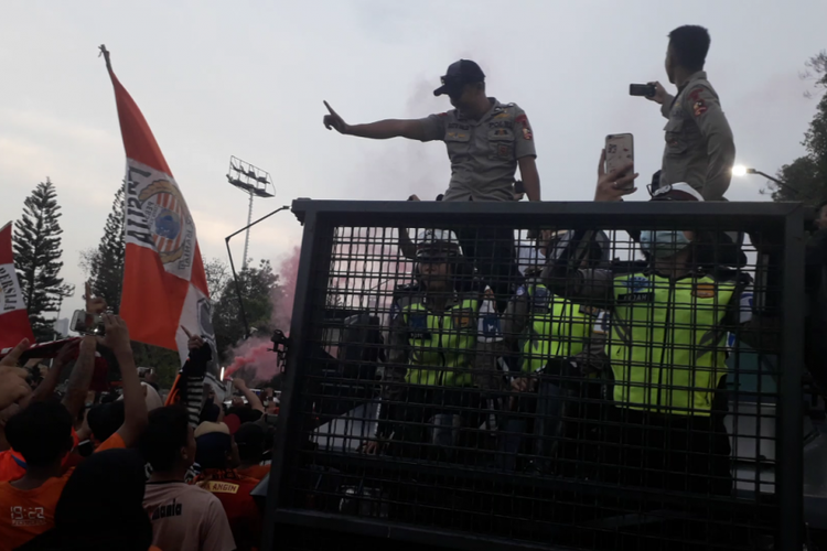 Polisi tampak mengabadikan momen pesta The Jakmania yang merayakan Persija juara Liga 1 Indonesia musim 2018 di Gelora Bung Karno, Minggu (9/12/2018).