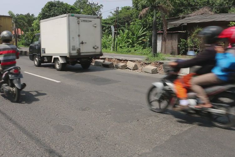 Sejumlah pengguna jalan melaju dari arah Jakarta menuju Jawa Tengah di jalur utama Pantura Kecamatan Depok, Kabupaten Cirebon, Jawa Barat, Sabtu (11/5/2019). Median jalan di titik tersebut tampak rusak. Material bebatuan besar dan kecil berserakan di pinggir jalan mengancam para pemudik. 