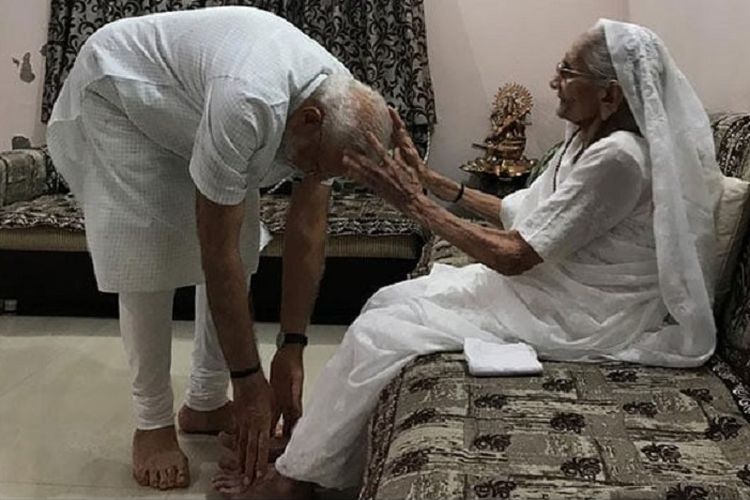 Perdana Menteri India, Narendra Modi (kiri) saat meminta doa restu dari ibundanya, Heeraben, di Ahmedabad, Gujarat, Minggu (26/5/2019).