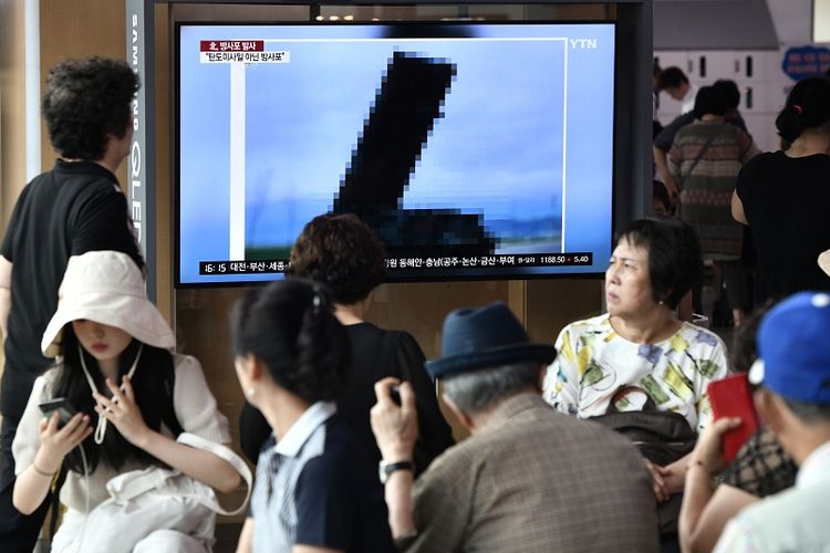 Warga menyaksikan berita di televisi yang menampilkan foto peluncur rudal terbaru Korea Utara, Kamis (1/8/2019).