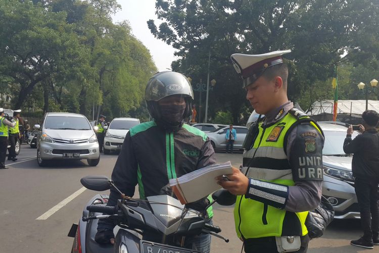 Polisi menilang pengendara sepeda motor yang belum membayar pajak kendaraan bermotor (PKB)-nya di Jalan Lapangan Banteng Selatan, Jakarta Pusat, Jumat (11/8/2017).