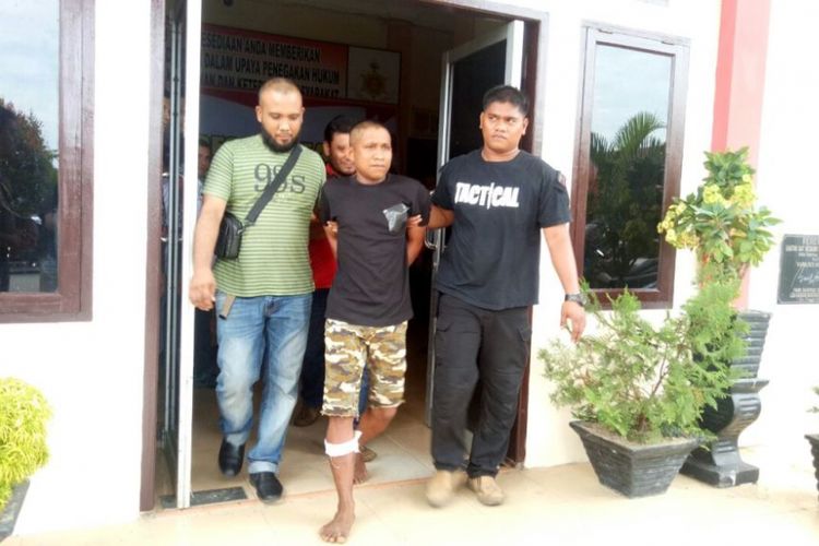 Polisi membawa Jefri, tersangka kasus pencabulan anak yang ditembak pada bagian betis kanannya di Mapolres Aceh Utara, Senin (18/9/2017)