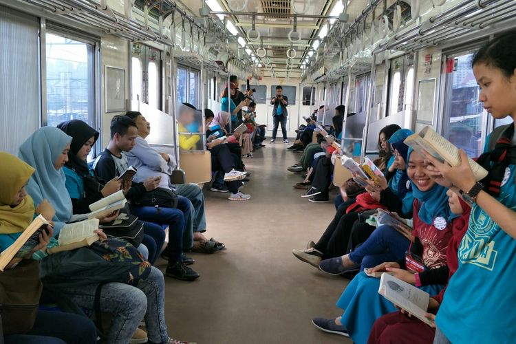 Relawan pegiat literasi mengampanyekan aksi membaca buku di dalam KRL dari Stasiun Jakarta Kota sampai Stasiun UI dalam rangka hari buku sedunia, Minggu (22/4/2018).