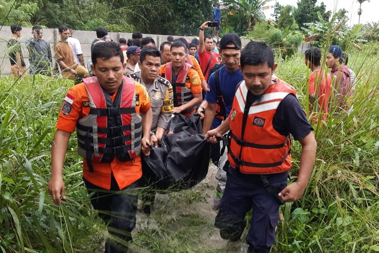 Tim Basarnas Pekanbaru, kepolisian dan pemadam kebakaran mengevakuasi jasad Yeni yang tewas akibat terseret banjir di Jalan Lobak, Kelurahan Delima, Kecamatan Tampan, Pekanbaru, Riau, Selasa (18/6/2019). 