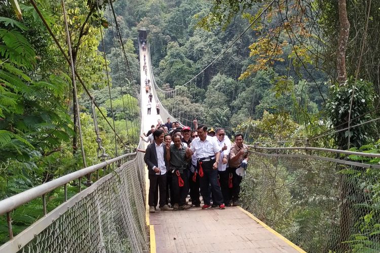 Menko Bidang Kemaritiman Luhut Binsar Pandjaitan (kanan ketiga) saat menyeberang jembatan gantung Situgunung, di Kadudampit, Sukabumi, Jawa Barat, Sabtu (9/3/2019). 