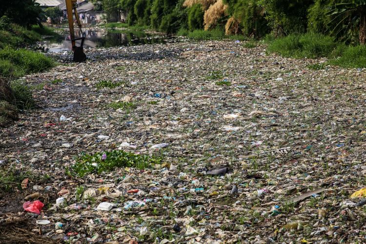 Sampah yang didominasi plastik memenuhi sepanjang Kali Pisang Batu, Desa Pahlawan Setia, Kecamatan Tarumajaya, Kabupaten Bekasi, Jawa Barat, Selasa (8/1/2019). Sampah yang memenuhi Kali Pisang Batu hingga sepanjang 1,5 kilometer berasal dari Kali Bekasi yang melewati Kota Bekasi. Sampah muncul pasca normalisasi dilakukan pada Desember 2018. Sebelumnya, kali hanya dipenuhi lumpur dan eceng gondok.