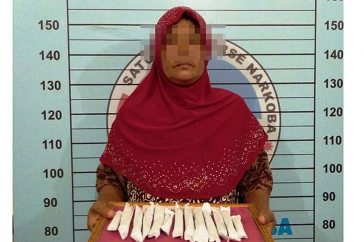 NH (45) ibu rumah tangga warga Desa Lancok, Kecamatan Syamtalira Bayu, Kabupaten Aceh Utara, memperlihatkan ganja barang bukti miliknya di Mapolres Aceh Utara, Rabu (10/10/2018). 