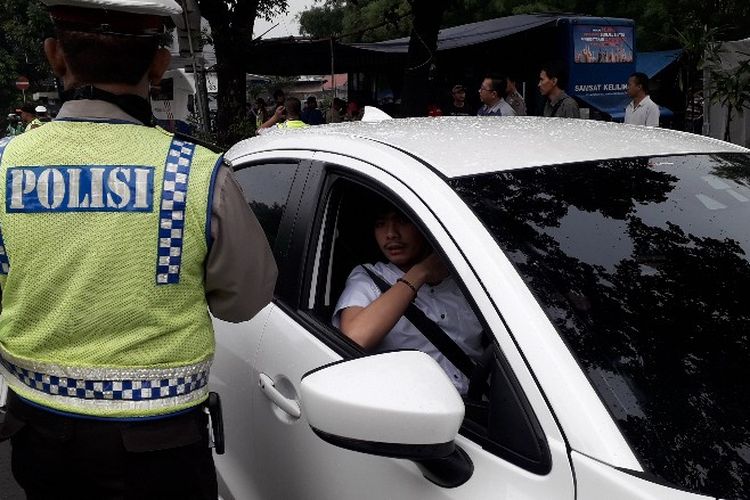 Seorang pengendara mobil dirazia karena tidak memiliki STNK dan belum memiliki plat nomor resmi. Ia mendapat surat tilang di Jalan Raya Kalibata, Jakarta Selatan pada Selasa (24/4/2018).