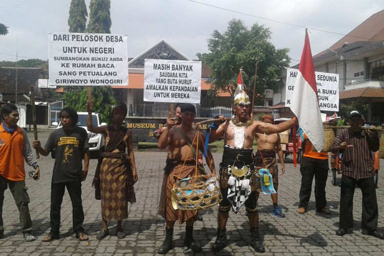 Gatotkaca memikul keranjang berisi buku bacaan di depan Museum Radya Pustaka Solo, Jawa Tengah, Senin (23/4/2018).