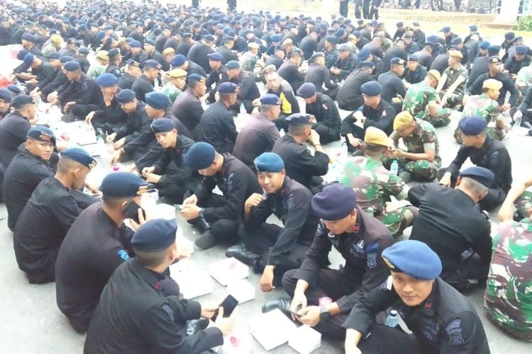 Tampak Brimob Mabes Polri bersama pasukan TNI buka puasa di atas aspal beralaskan kardus di depan Kantor Bawaslu RI, Jalan MH. Thamrin, Jakarta Pusat, Sabtu (25/5/2019).