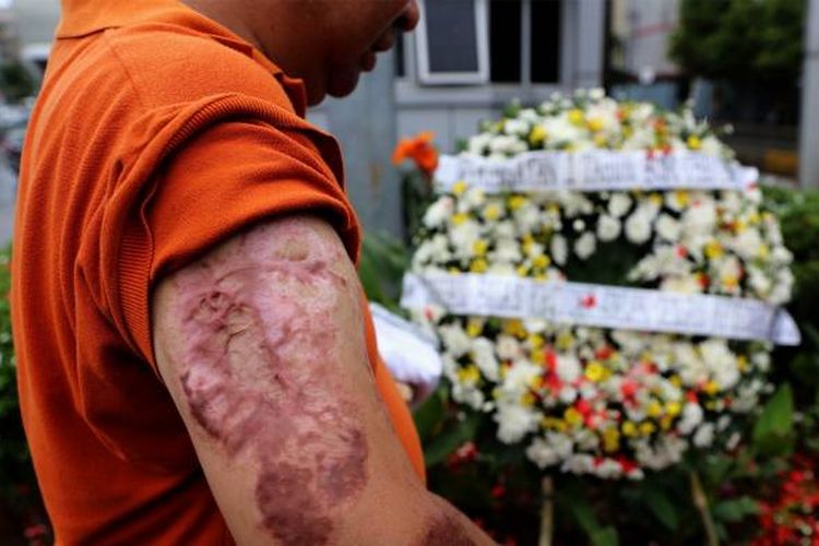 Aiptu Denny Mahieu salah satu korban yang selamat melakukan tabur bunga di Sarinah, Thamrin, Jakarta, Sabtu (14/1/2017). Mereka mengenang kembali aksi terorisme yang terjadi siang hari tepat setahun lalu.