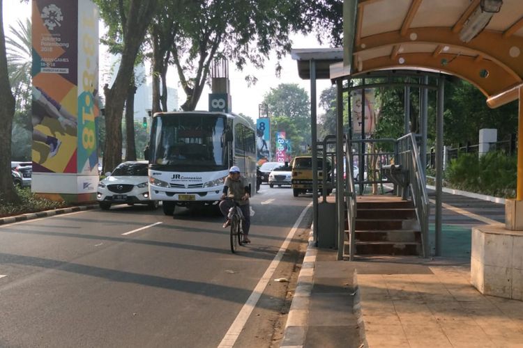 Seorang pesepeda bersepeda di ruas Jalan Asia Afrika, Senayan, Jakarta, Selasa (31/7/2018). Dia tidak menggunakan jalur sepeda di trotoar. Di sisi lain, jalur sepeda di trotoar itu juga terhalang tiang.