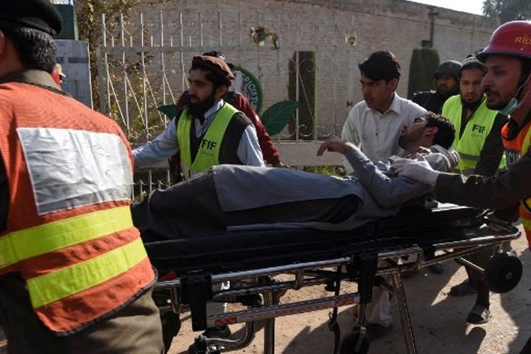 Petugas paramedis membawa korban serangan Taliban di sekolah Pakistan. Kepolisian mengonfirmasi telah melumpuhkan seluruh pelaku penembakan yang telah menewaskan sembilan orang tersebut. (1/12/2017)