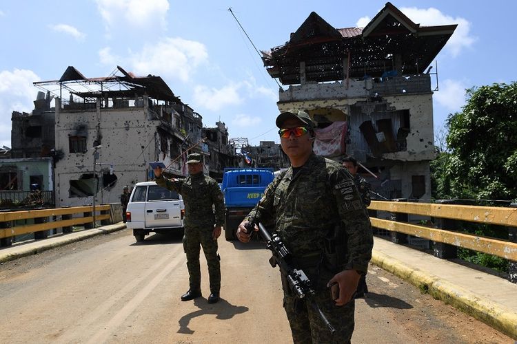 Prajurit Filipina berjaga di Jembatan Mapandi, Marawi di saat warga kota mulai berdatangan menengok rumah mereka di pusat pertempuran untuk mengambil barang-barang yang masih bisa diselamatkan. 