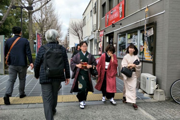 Wisatawan mengenakan kimono saat jalan-jalan di kawasan Miyuki-dori, Himeji, Jepang, Minggu (4/3/2018).